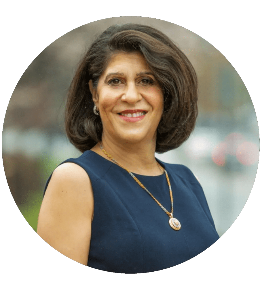 A woman with dark hair, brown eyes, red lips and a black sleeveless dress smiling at the camera. She is also wearing a lon...