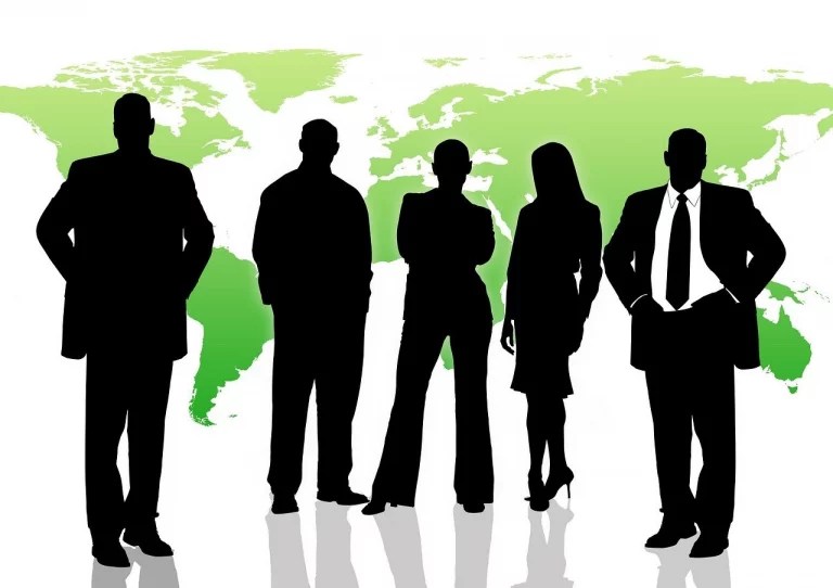 Group of business professionals in front of world map solid black silhouette.